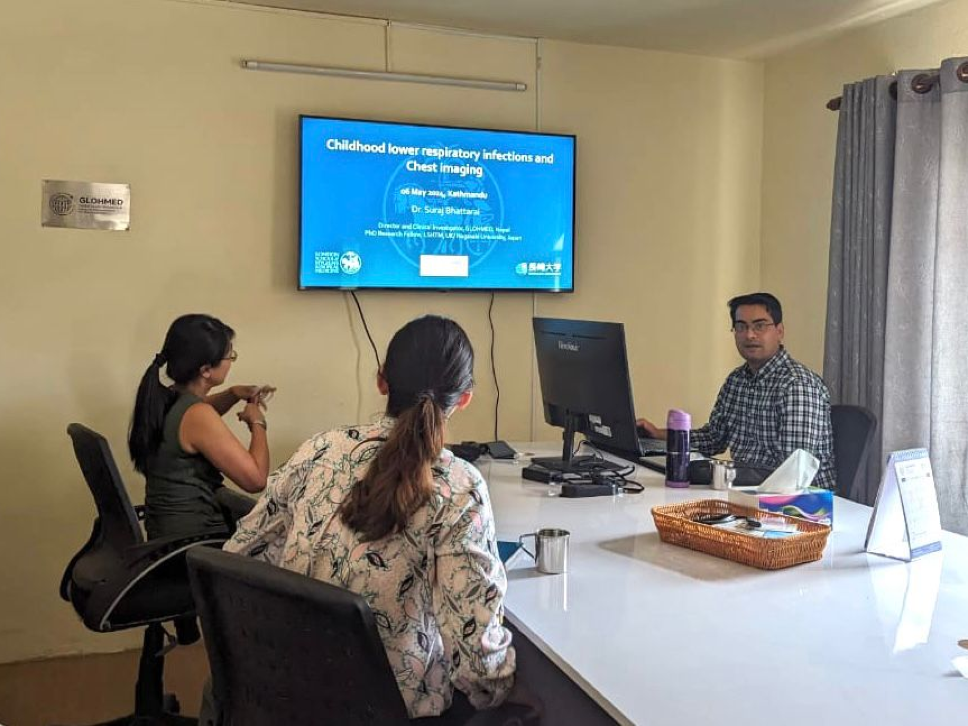 Dr. Bhattarai discussing childhood lower respiratory infections and the role of chest imaging during a seminar at GlohMed meeting hall.
